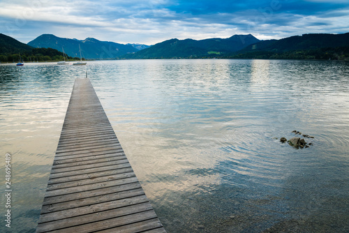 Picturesque view of wooden pier in the beach of Tegernsee lake near Gmund am Tegernsee in Germany. Space in right side