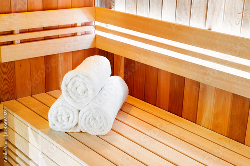 Traditional classic wooden sauna for relaxation with bucket of water and towels