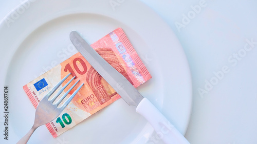Euro banknote on a white plate, cash in Europe, the cost of lunch in the restaurant