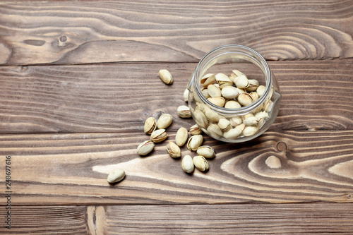Roasted pistachios in a glass jar. Old wooden background. shallow depth of cut