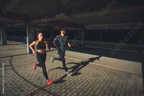 Young sports couple running in the urban environment