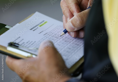 A golfer checks his scorecard during a tournament photo