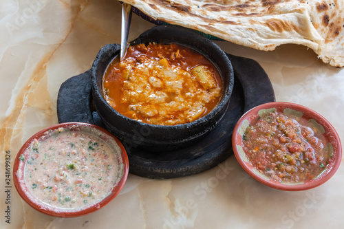 Saltah dish, meze plates and flat bread. photo