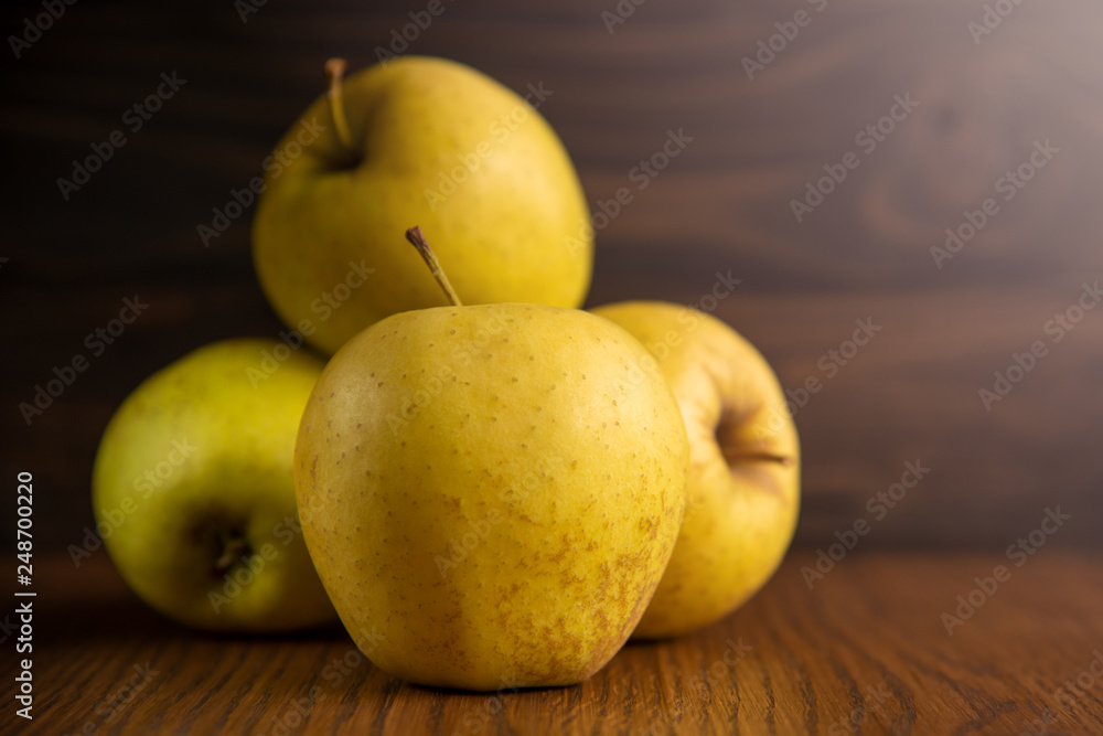 Yellow apple on the wooden vintage background