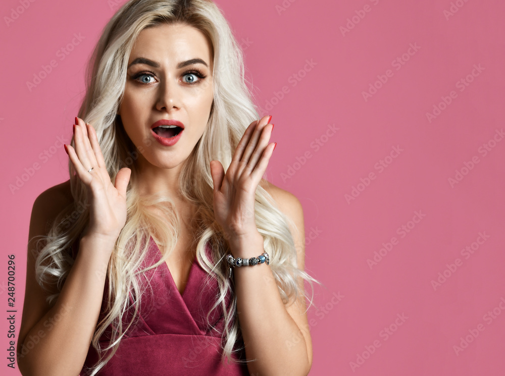 Excited screaming young blonde woman standing surprised on pink Excited screaming young blonde woman standing surprised on pink