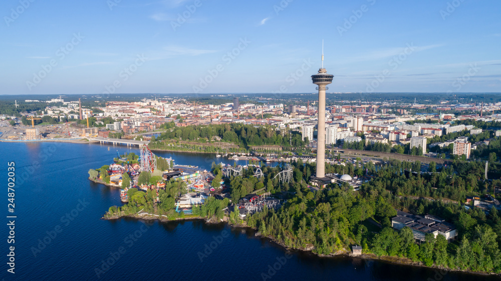 Beautiful summer panorama of the Tampere city. View from the lake. Observation tower and amusement park on the shore.