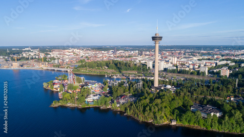Beautiful summer panorama of the Tampere city. View from the lake. Observation tower and amusement park on the shore. © raland