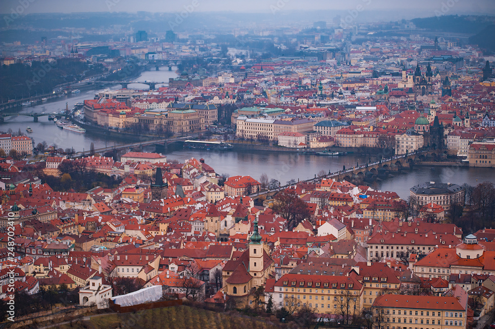 View of the red roofs, Vltava and bridges in Prague. Stare Misto and Mala Strana. Overcast weather
