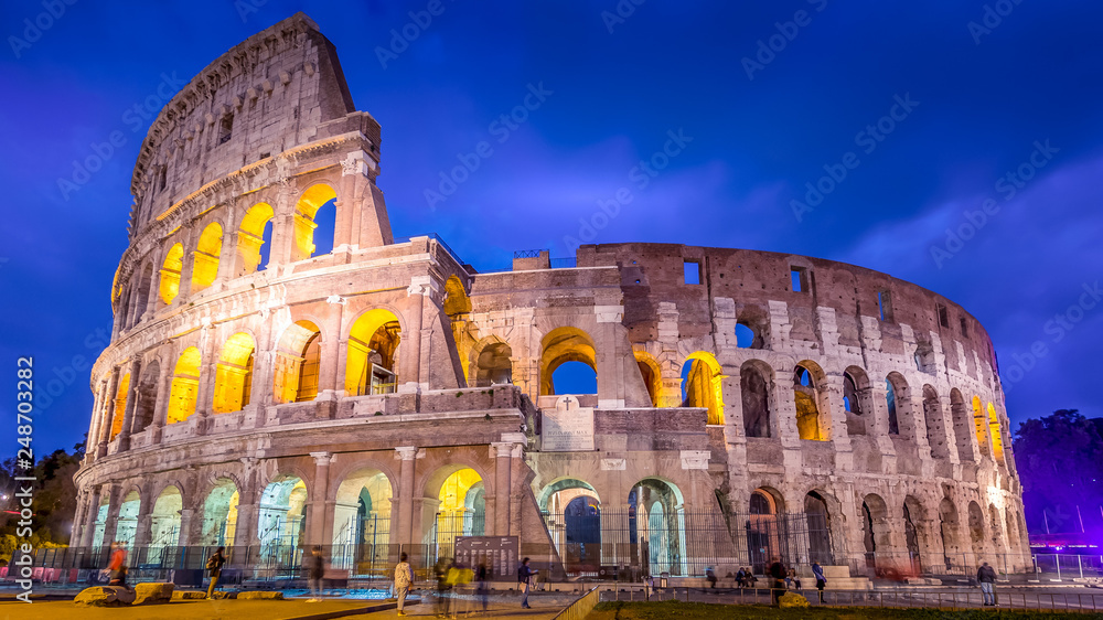 Roman Colosseum and tourists as night falls in Rome, Italy, blurred faces for commercial use