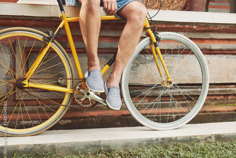 Naklejka premium Attractive man sitting with old bicycle.
