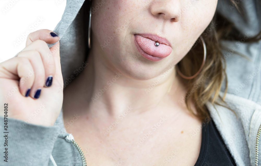 Young teen girl with tongue piercing and hoodie Stock Photo | Adobe Stock