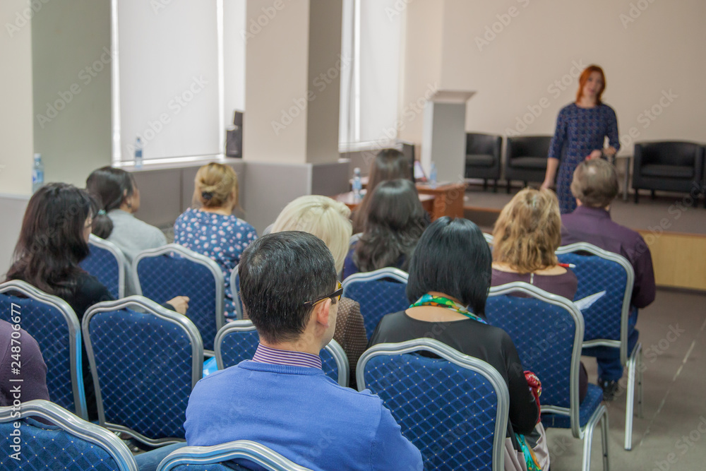 The speaker makes a report at a business meeting. Spectators in the conference room. Business and entrepreneurship. The speaker makes a report at a business meeting. Spectators in the conference room. Business and entrepreneurship.