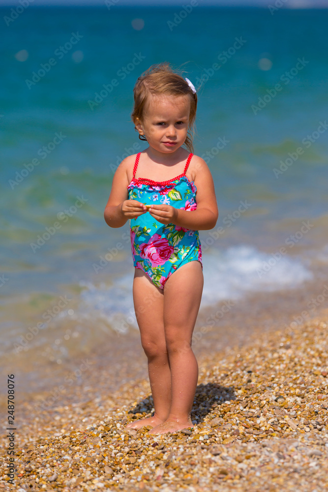 Cute little girl playing on the seashore Cute little girl playing on the seashore
