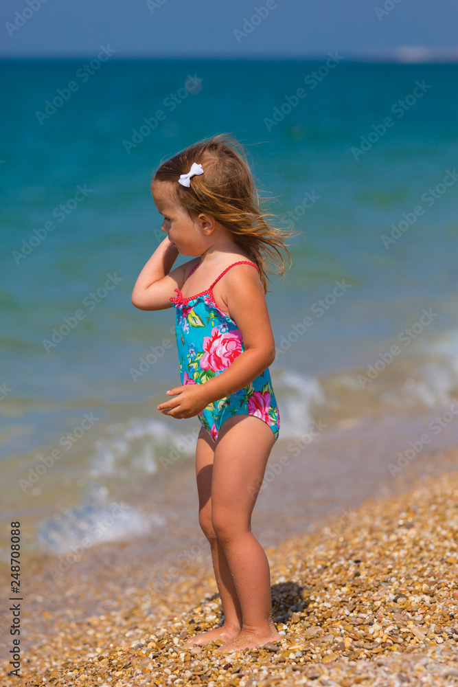 Cute little girl playing on the seashore Cute little girl playing on the seashore
