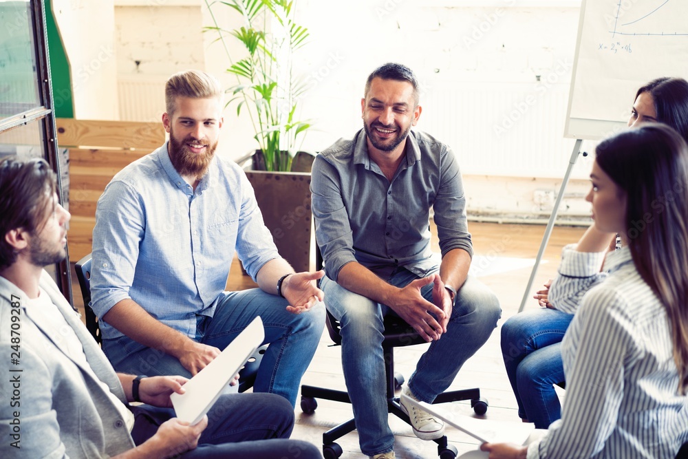Teamwork is a key to success. Business people in smart casual wear talking and smiling while having a brainstorm meeting in office. Teamwork is a key to success. Business people in smart casual wear talking and smiling while having a brainstorm meeting in office.