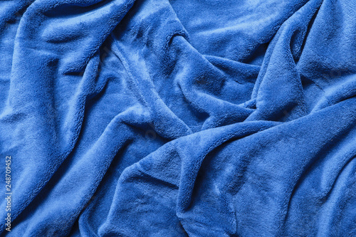 Wavy soft blue blanket background. Winkled plush canvas texture.