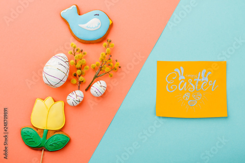 Spring Easter background with sweets. Happy Easter colorful background with decorations and paper card. Easter symbols and attributes.