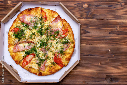 Pizza with tomatoes. Top view on wooden table with copy space for your text