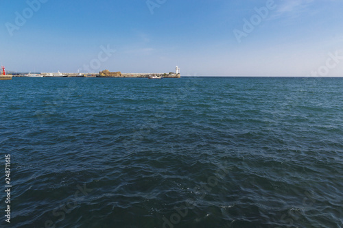 Fototapeta Naklejka Na Ścianę i Meble -  Landscape from the embankment of Yalta. View of the Bay and the lighthouse