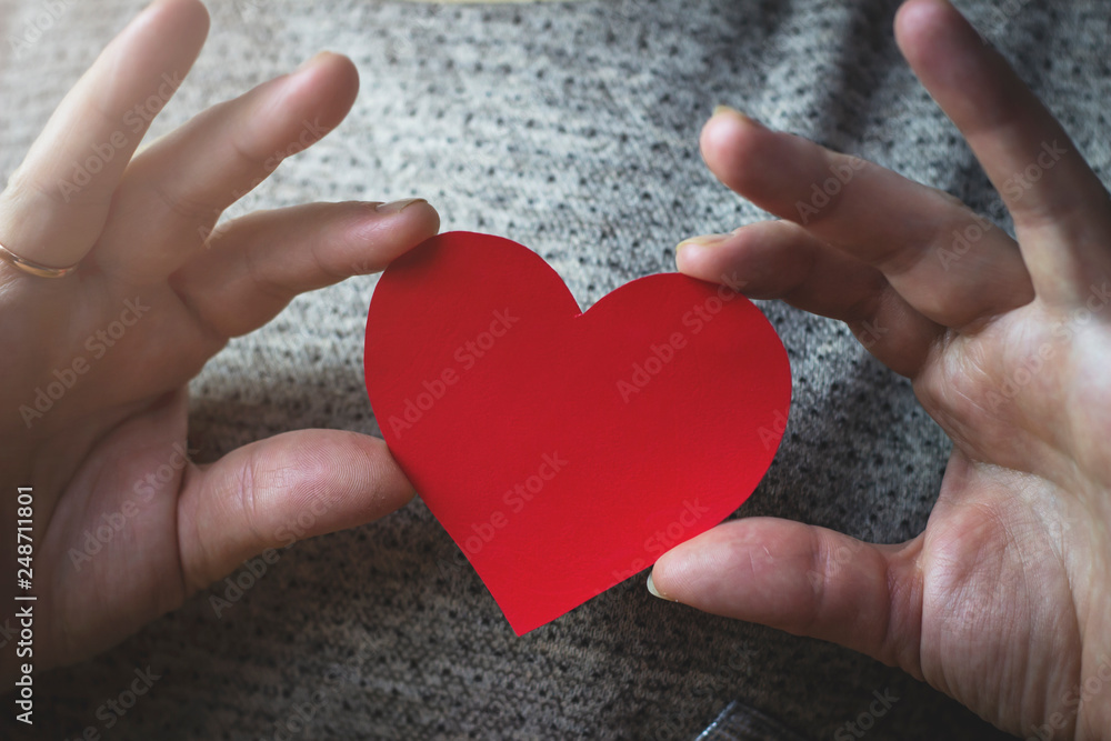 Woman holding hands red heart near chest