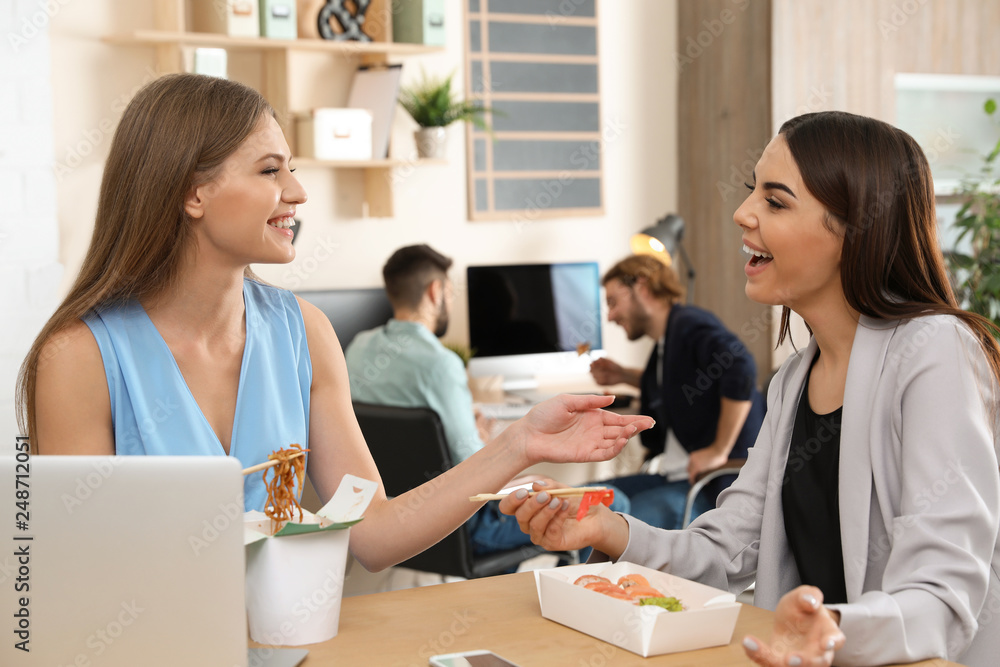 Office employees having lunch at workplace. Food delivery Office employees having lunch at workplace. Food delivery
