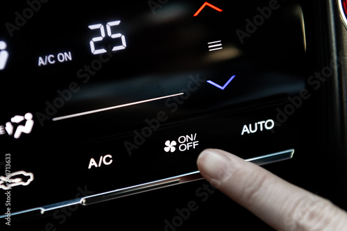 finger woman car driver push on or off air condition button while having a temperature of 25 degrees