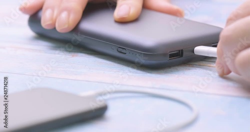 Hand holding USB type C into power bank. Closeup.