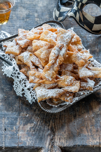 Traditional Italian carnival fritters dusted with icing sugar - frappe or chiacchiere photo