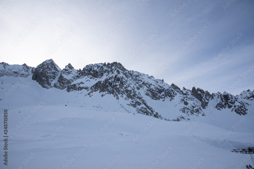 View of the Presena glacier at 3100 meters of altitude and the mountains around the Tonale Pass, during a winter sunny day. Tonale is a mountain pass between Lombardy and Trentino