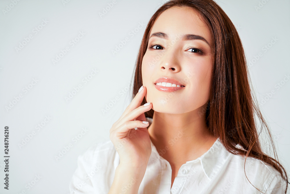 Beauty portrait of smiling sensual asian young woman with clean fresh skin in white shirt isolated Beauty portrait of smiling sensual asian young woman with clean fresh skin in white shirt isolated
