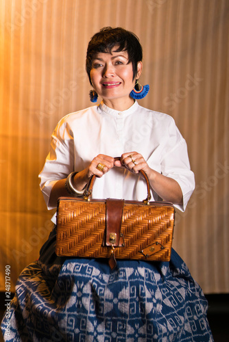 Femme assise avec un sac à main en osier