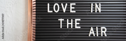 Love is in the air text on dark and white background, inscription, copy space, banner