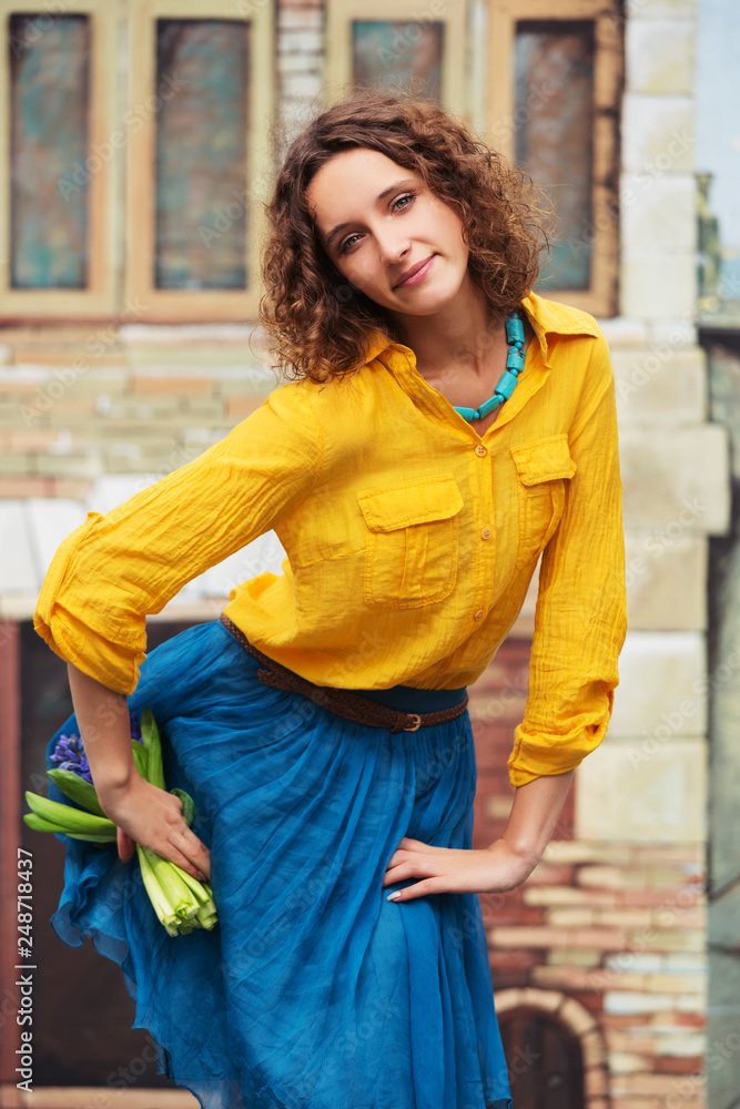 Happy young fashion woman in yellow shirt with bouquet of flowers Happy young fashion woman in yellow shirt with bouquet of flowers