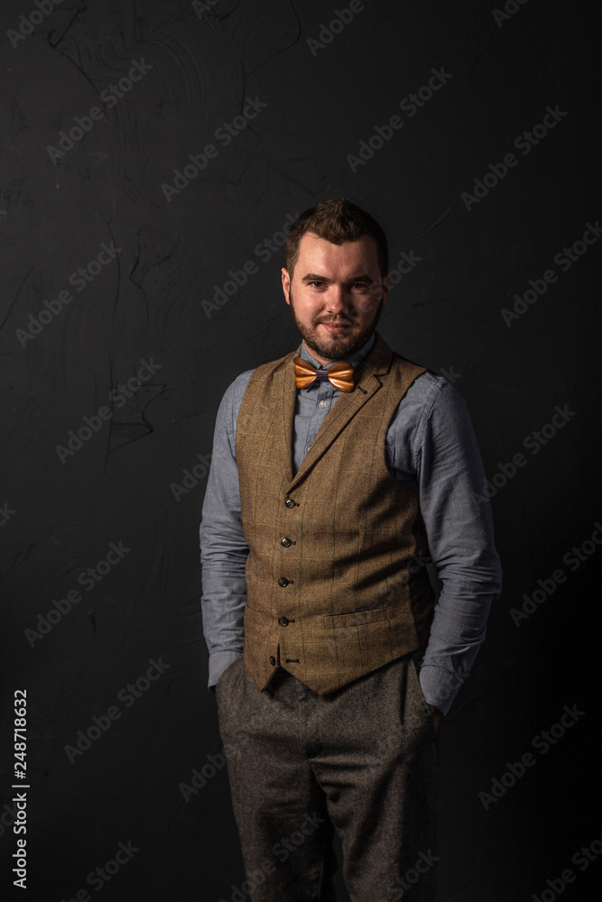 Stylish young man in wooden bowtie. Business style. Fashionable image. Office worker. Sexy man standing and looking at the camera