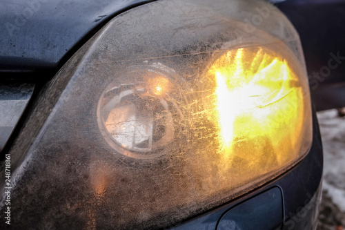 Fotografie Car front headlights, scratched, dirty and opaque, blurred