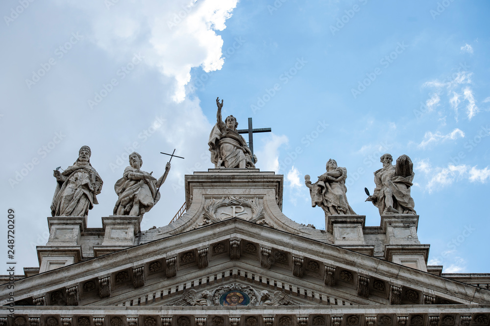 Rome, Italy May 13, 2016: Statues of Christ and some saints on the top of Saint John Lateran Basilica facade.