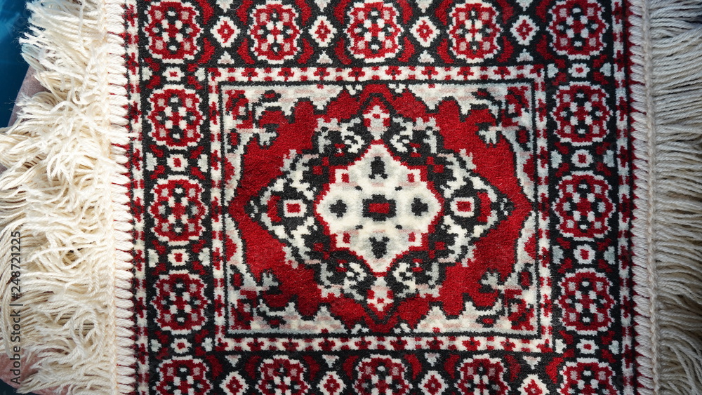 Bright colorful weaved floor mat. Turkish ornamental carpet background. Woven texture. Ethnic pattern rug. Traditional Asian ornaments. Turkish bazaar backdrop.