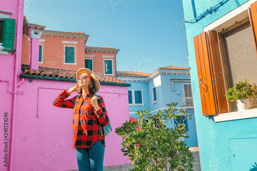 Happy asian traveler woman having fun on well known Burano island near Venice. Travel and vacation in Italy concept