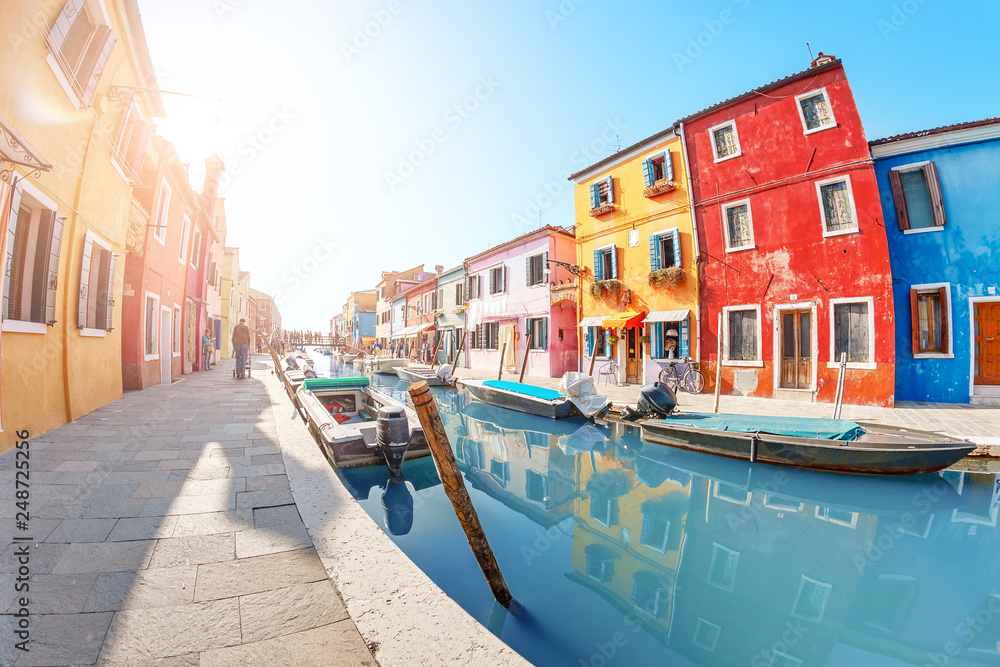 Panoramic view of the canal with boats and colorful original houses on the island of Burano in Venice. Holidays in Italy and Europe concept