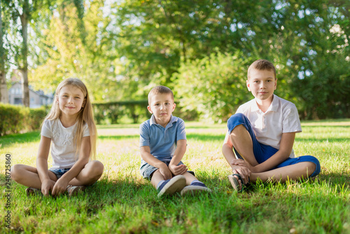Children sit on the fresh green grass