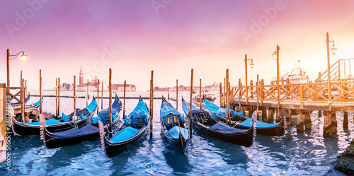 Majestic Gondolas in Venice at the sunset. Panoramic view of the San Giorgio Maggiore church from San Marco square. Travel and Vacation in Italy concept