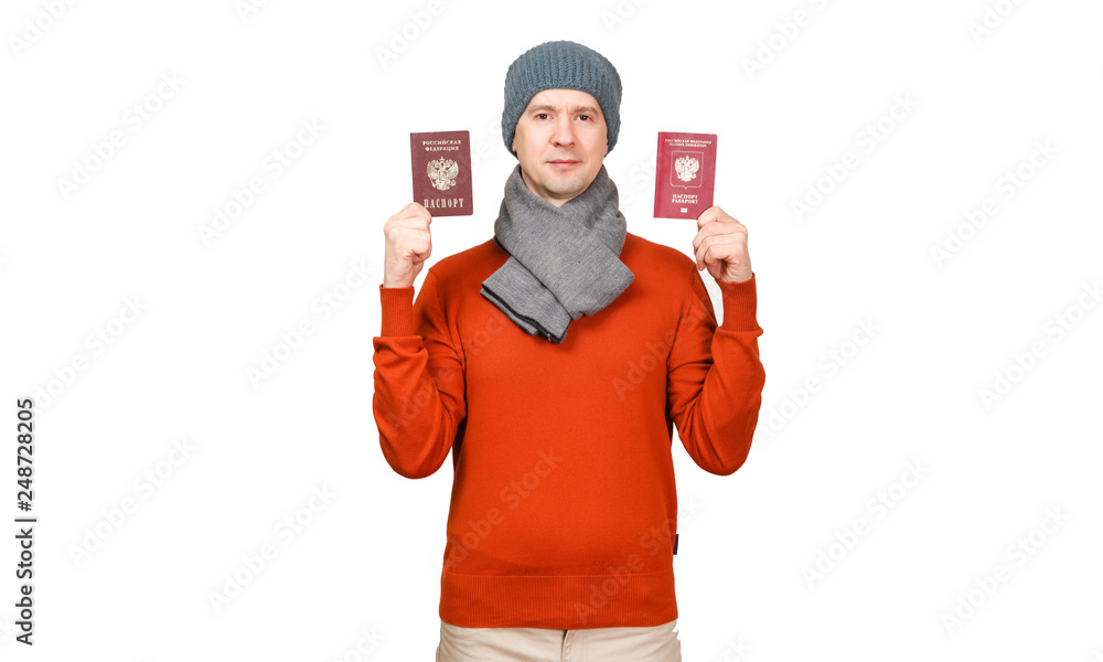 The Caucasian man keeps two Russian Federation citizen passports in warm clothes on a white background The Caucasian man keeps two Russian Federation citizen passports in warm clothes on a white background