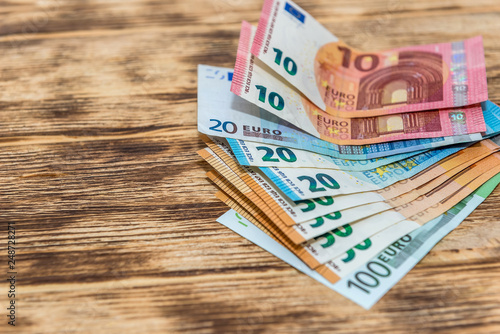 Euro banknotes in fan at wooden desk