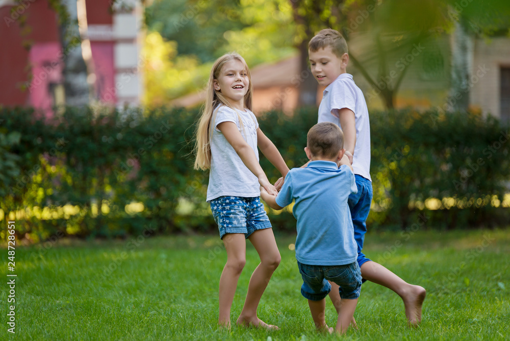 Fototapeta premium Children play on the lawn barefoot