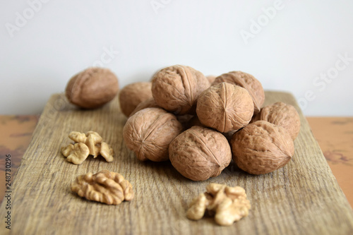 Walnuts and walnut kernels on an old wooden board close-up