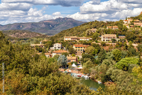 A village in the mountains in a clear summer sunny day, red rocks of Esterel massif, Provence, Southern France. Holidays in France.