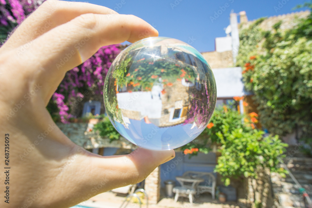 hand sujeranto crystal ball reflecting a house with swimming pool