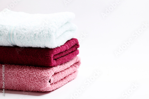 A set of towels of different colors on a white background. Place for text