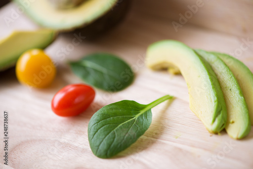 Close-up of a fresh juicy green ripe avocado on wooden table. Healthy food