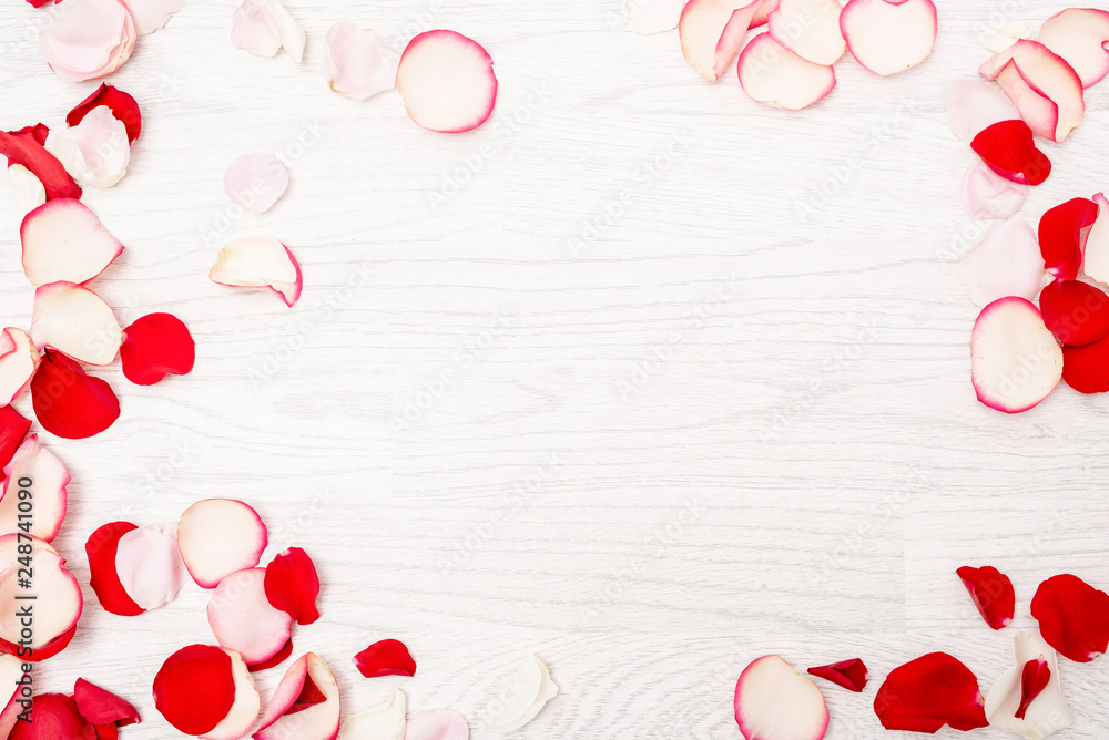 Frame made from pink, red, white roses on vintage white wooden background effect. Flat lay, top view. Frame made from pink, red, white roses on vintage white wooden background effect. Flat lay, top view.